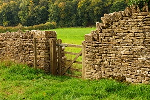 Dry stone wall and wooden gate forming a traditional boundary se, a Photo by Studio ANNA