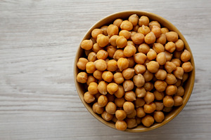 Organic Raw Canned Chickpeas in a Bowl, overhead view. Copy spac, a Food & Drink Photo by LiudmylaChuhunova