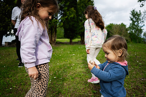 Children playing outdoors on a sunny day in a natural grassy environment, a Person Photo by AS photostudio