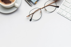 Office desk with coffee, clipboard, glasses, pen, keyboard and c, a Business Photo by Olena Rudo
