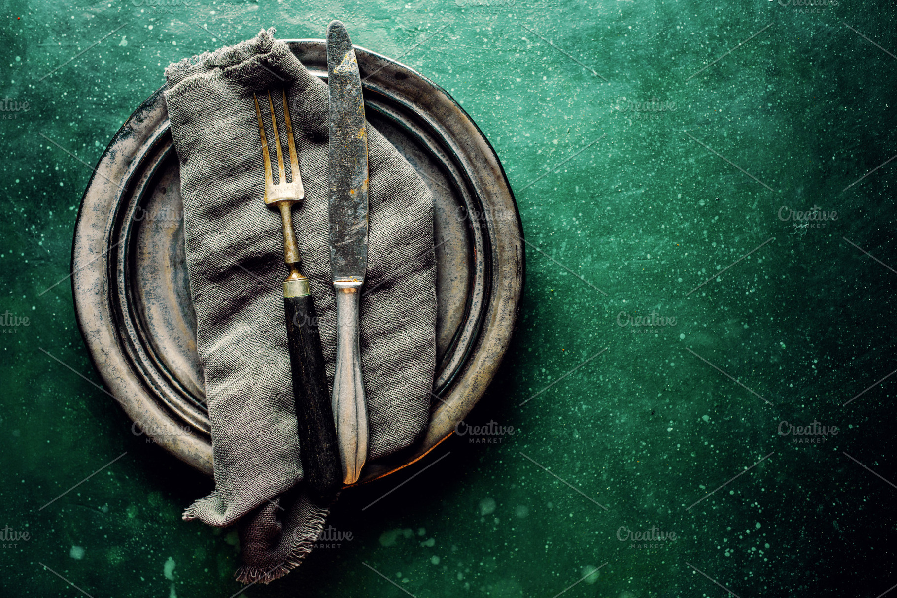 Vintage cutlery on plate on green ta, a Food & Drink Photo by Valeria Art