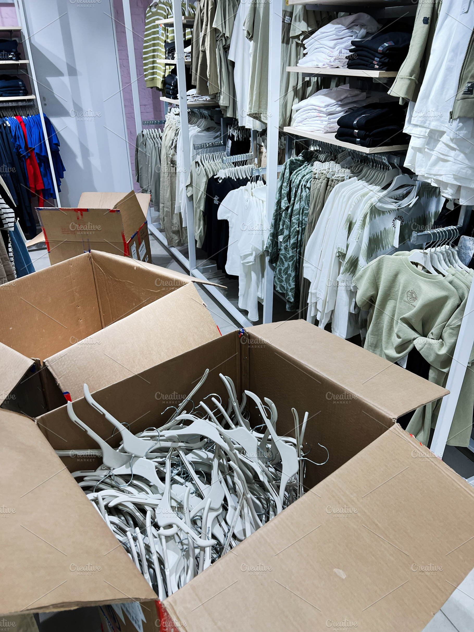 Cardboard Box Full of Hangers in Clothing Retail Store Interior, a Photo by AS photostudio