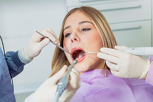 Dentist performing dental check up on young woman in clinic, a Health & Medical Photo by Antonio Gravante Market