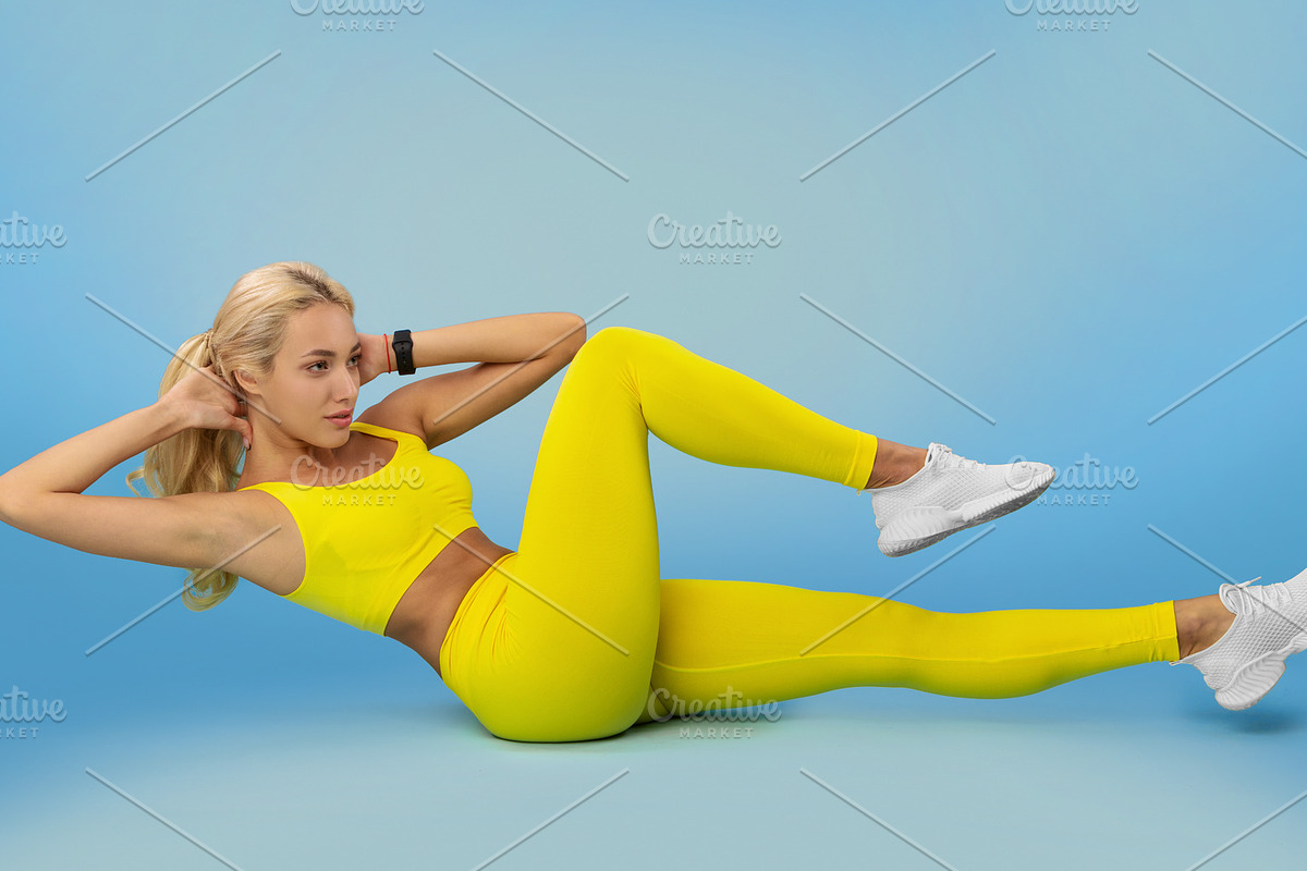 Smiling Young Woman Doing Abs Exercise, Side Crunches, a Photo by Prostock-Studio (Photo 2 of 2)