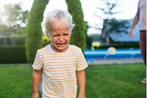 Crying toddler boy standing in, a Person Photo by HalfPoint