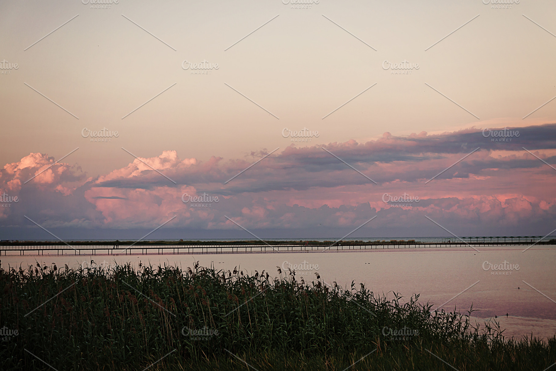 Landscape long bridge over a sea plait on a beautiful pink sunse, a Nature Photo by TanaCh