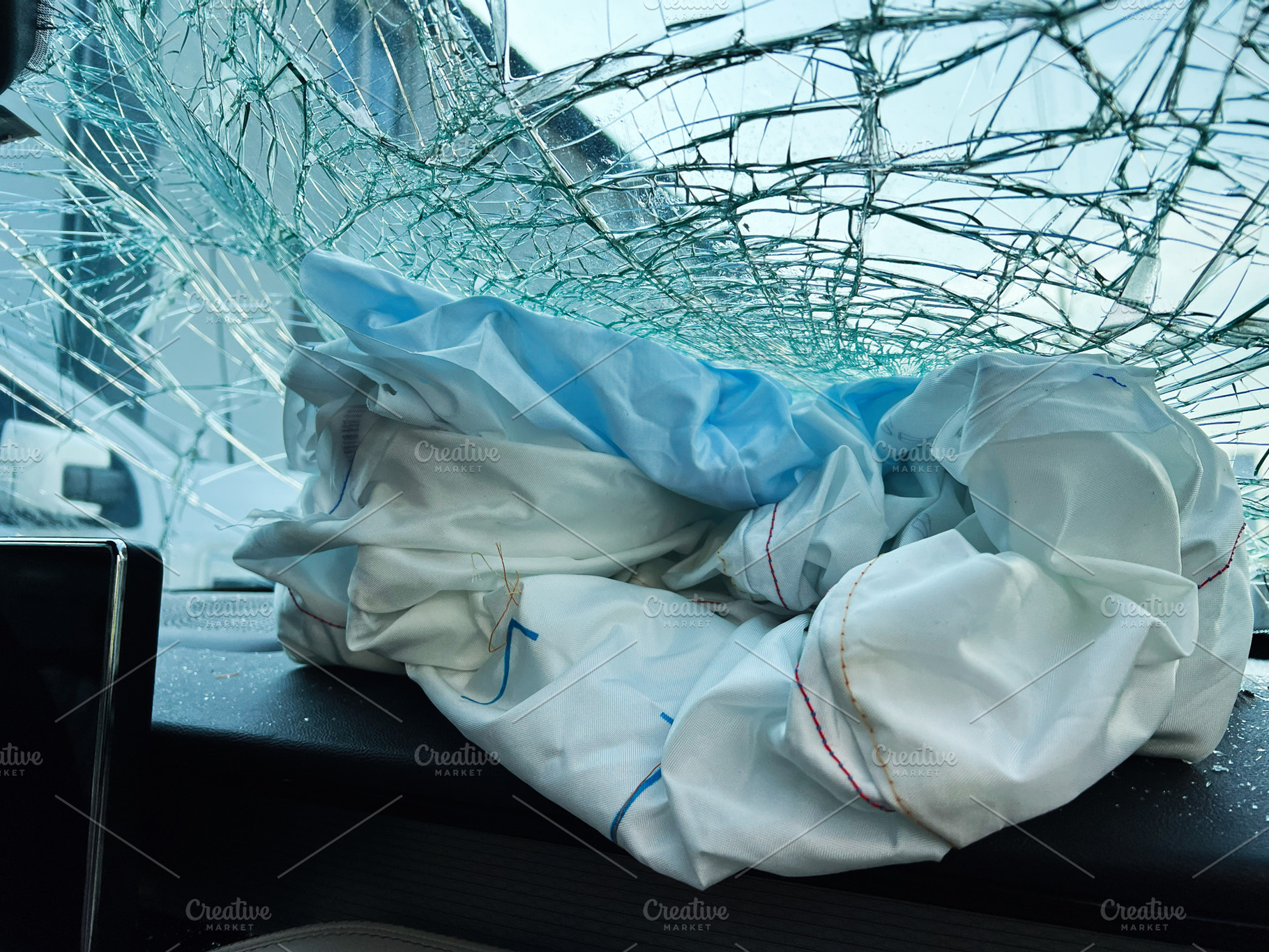Airbag deployment and shattered windshield after a vehicle collision accident, a Photo by AS photostudio