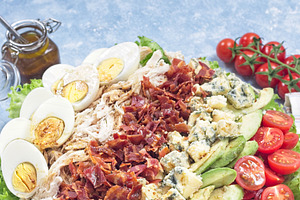 Delicious Cobb salad with greens, tomato, avocado, blue cheese, bacon, chicken, a Food & Drink Photo by iuliia_n