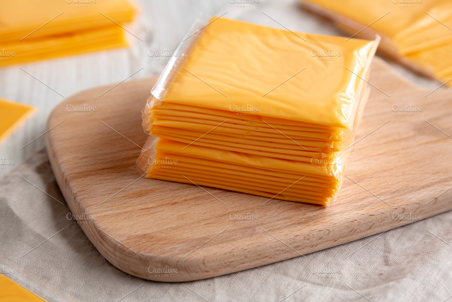Stack of American Cheese Slices in Wrappers, side view. Close-up, a Food & Drink Photo by LiudmylaChuhunova
