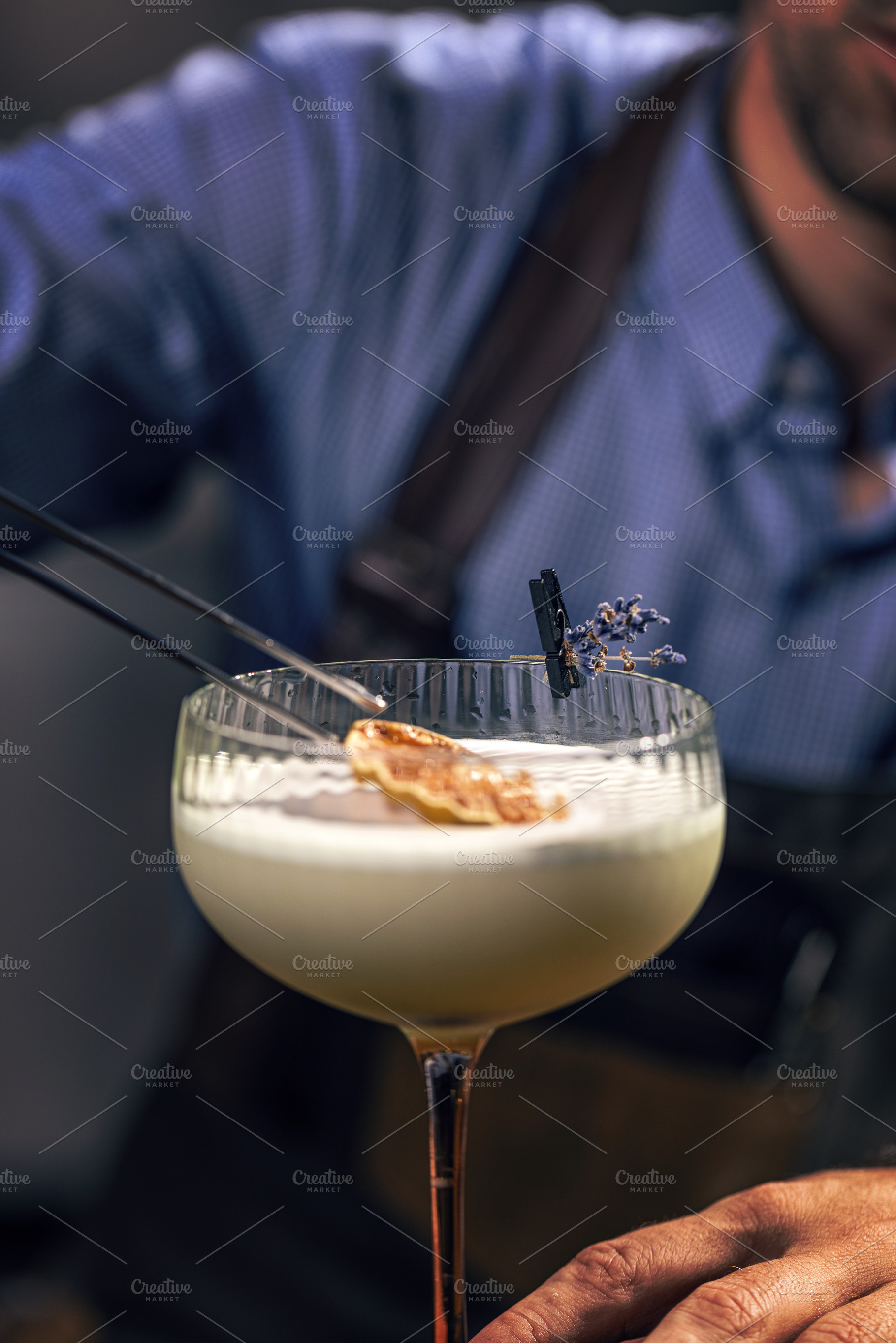 Bartender garnishing cocktail, a Photo by Grafvision photography