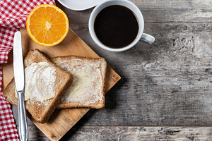 Sliced fresh bread with butter and coffee for breakfast on wooden table, a Food & Drink Photo by etorres69
