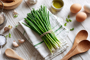 Fresh green onions laid out on a kitchen towel with eggs and garlic in a cozy k, a Food & Drink Photo by AlyaAnd