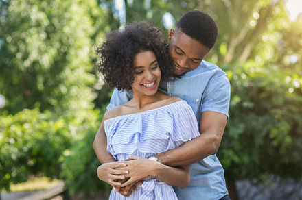 Smiling couple embracing in park on, a Person Photo by Prostock-Studio