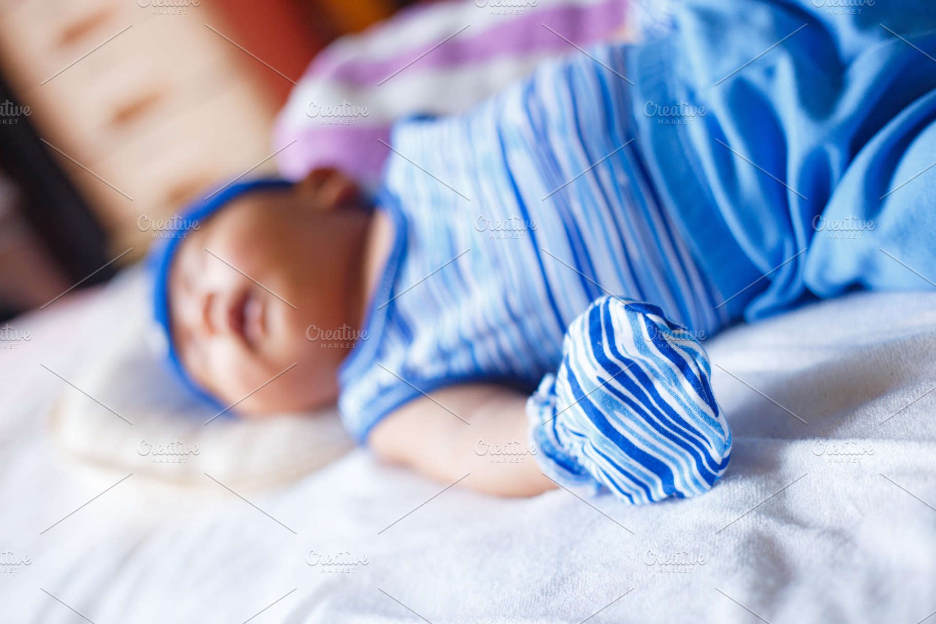 peaceful baby in blue clothing sleeps on soft bed, a Person Photo by a454