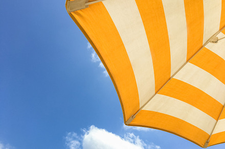 Yellow umbrella on the beach, an Abstract Photo by KYNA STUDIO
