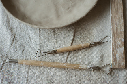 Ceramics in pottery workshop set featuring tools, pottery, and sculpting