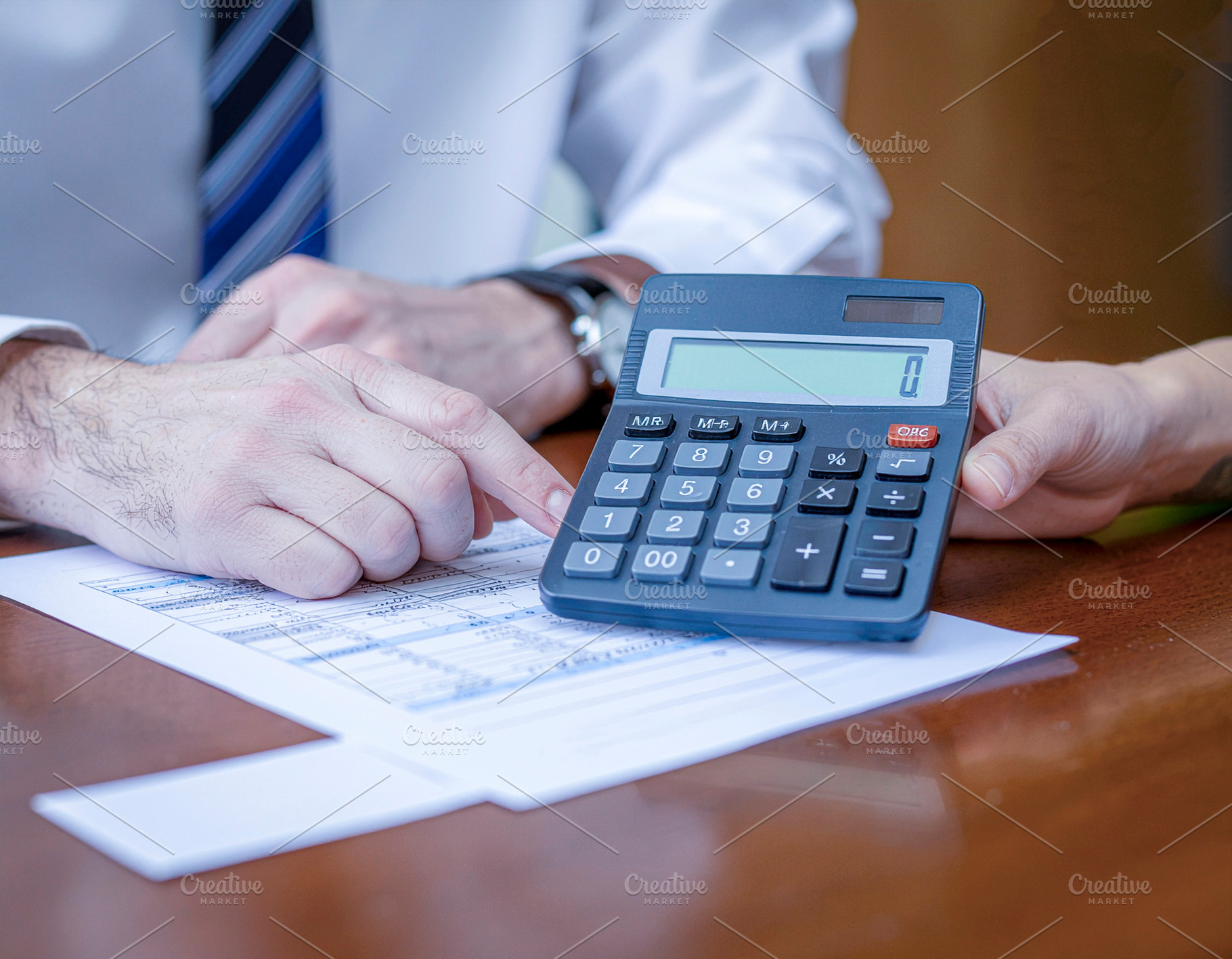Financial review with calculator and documents, a Photo by DanFLCreativo