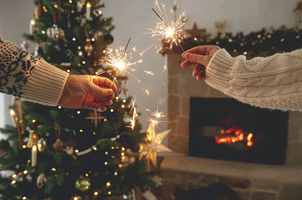 Happy New Year! Burning sparklers in hands on background of mode, a Holiday Photo by Sonjachni