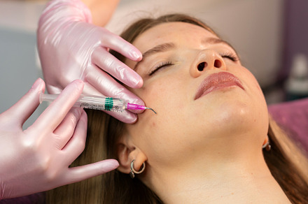 Aesthetician applying curved‑needle