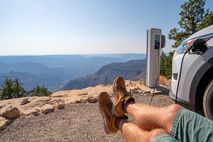 Relaxing at a canyon overlook with electric vehicle, a Person Photo by AlyaAnd