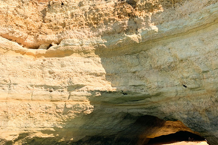 Algarve coastal cave with turquoise water and sunlight illuminat
