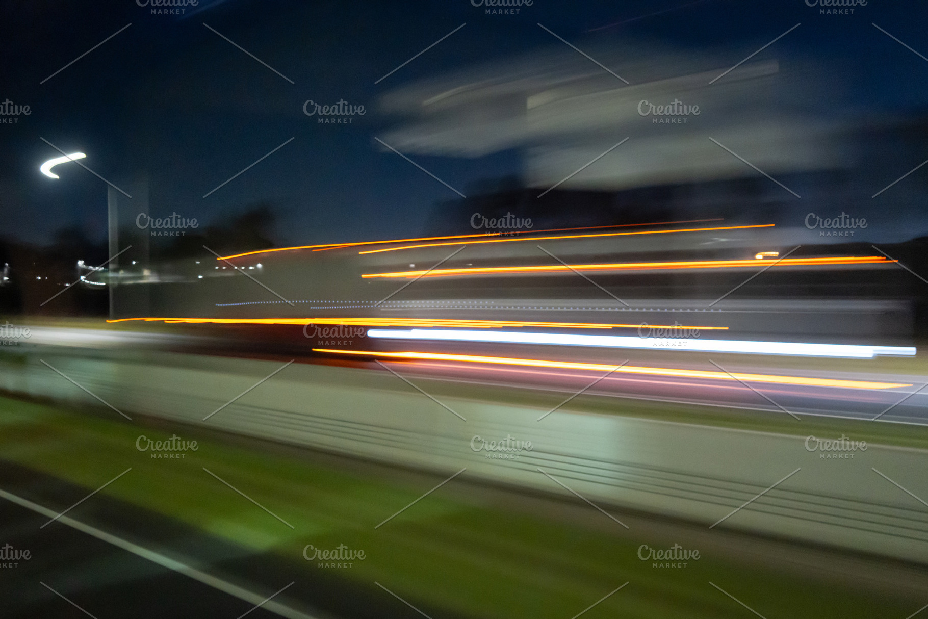 Light trails of a moving vehicle at night on the road, an Architecture Photo by GoodGoods
