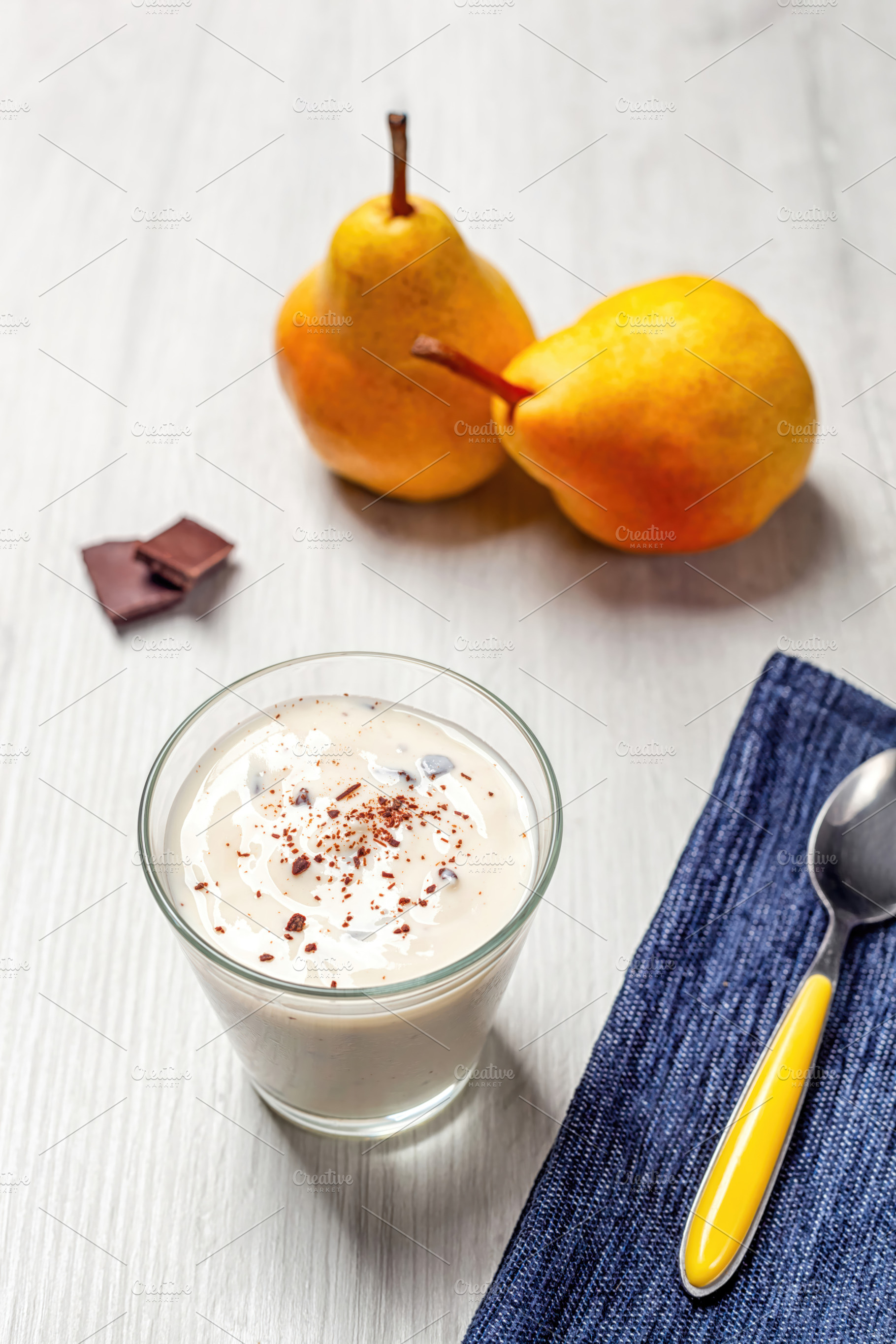 Yogurt with grated chocolate and pears on white wooden table, a Food & Drink Photo by Antonio Gravante Market