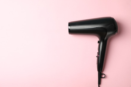 Black hair dryer on pink background, space for text, a Beauty & Fashion Photo by AtlasStudio PRO