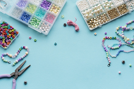 Colorful assortment of beads and jewelry-making tools on a blue, an Arts & Entertainment Photo by Olena Rudo