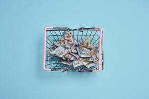 A metal shopping basket with pink handles filled with crumpled d, a Business Photo by ndanko