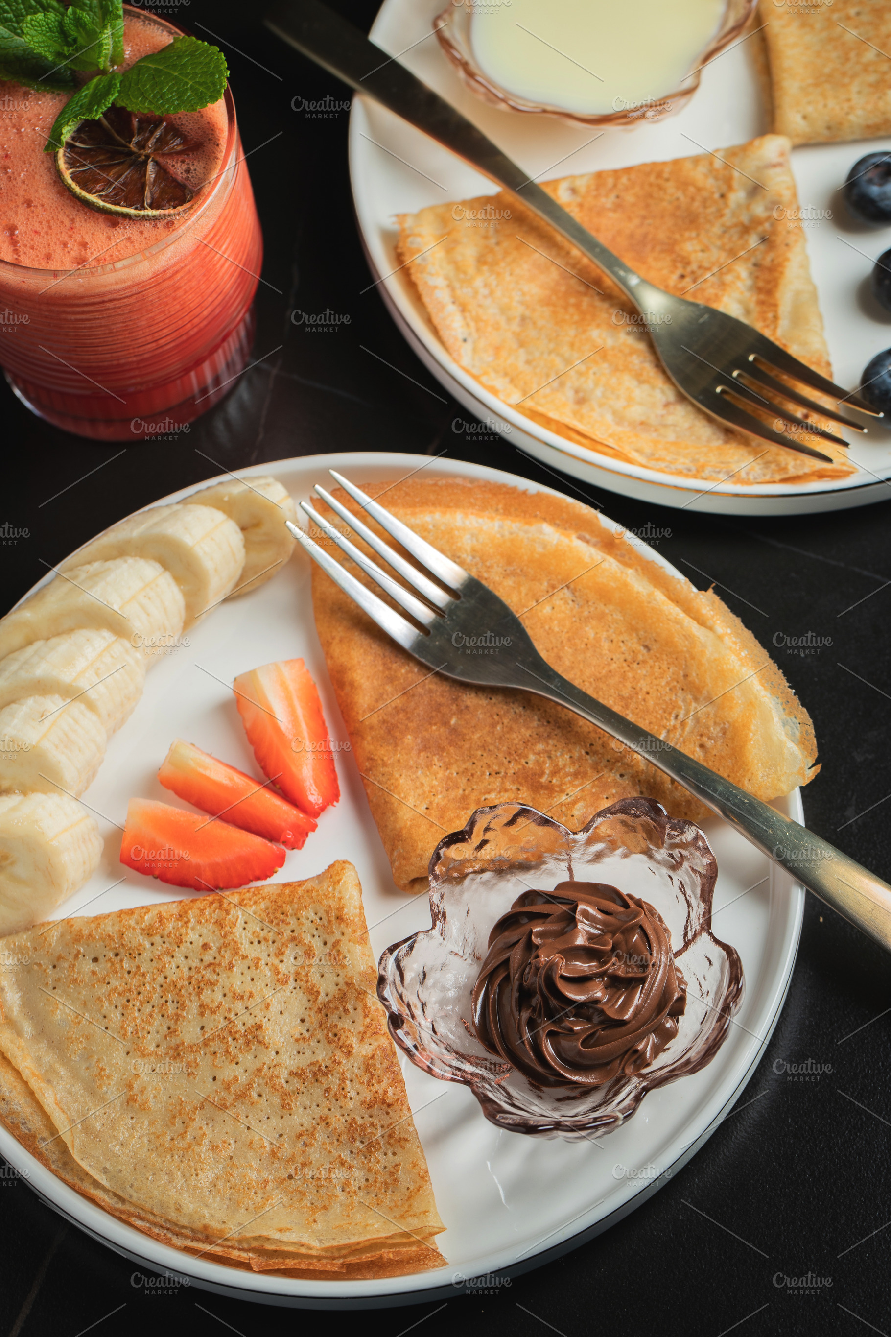 A plate of crepes filled with chocolate spread and topped with banana slices an, a Food & Drink Photo by Budarinphoto