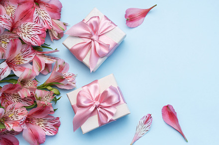 Beautiful Alstroemeria flowers and gift boxes on blue background, a Holiday Photo by Olena Rudo