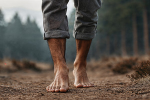 Barefoot wandering through forest path in serene morning light, a Person Photo by OSORIOartist