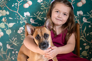 Young girl sitting on a wooden chair, holding and hugging her sm, a Person Photo by Imaginarium