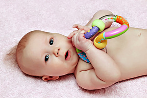 Newborn baby with colorfull rattle, a Photo by saiko3p