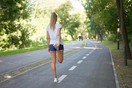 Woman runner stretching legs before containing woman, warming up, and exercise, a Sports & Recreation Photo by andreonegin market