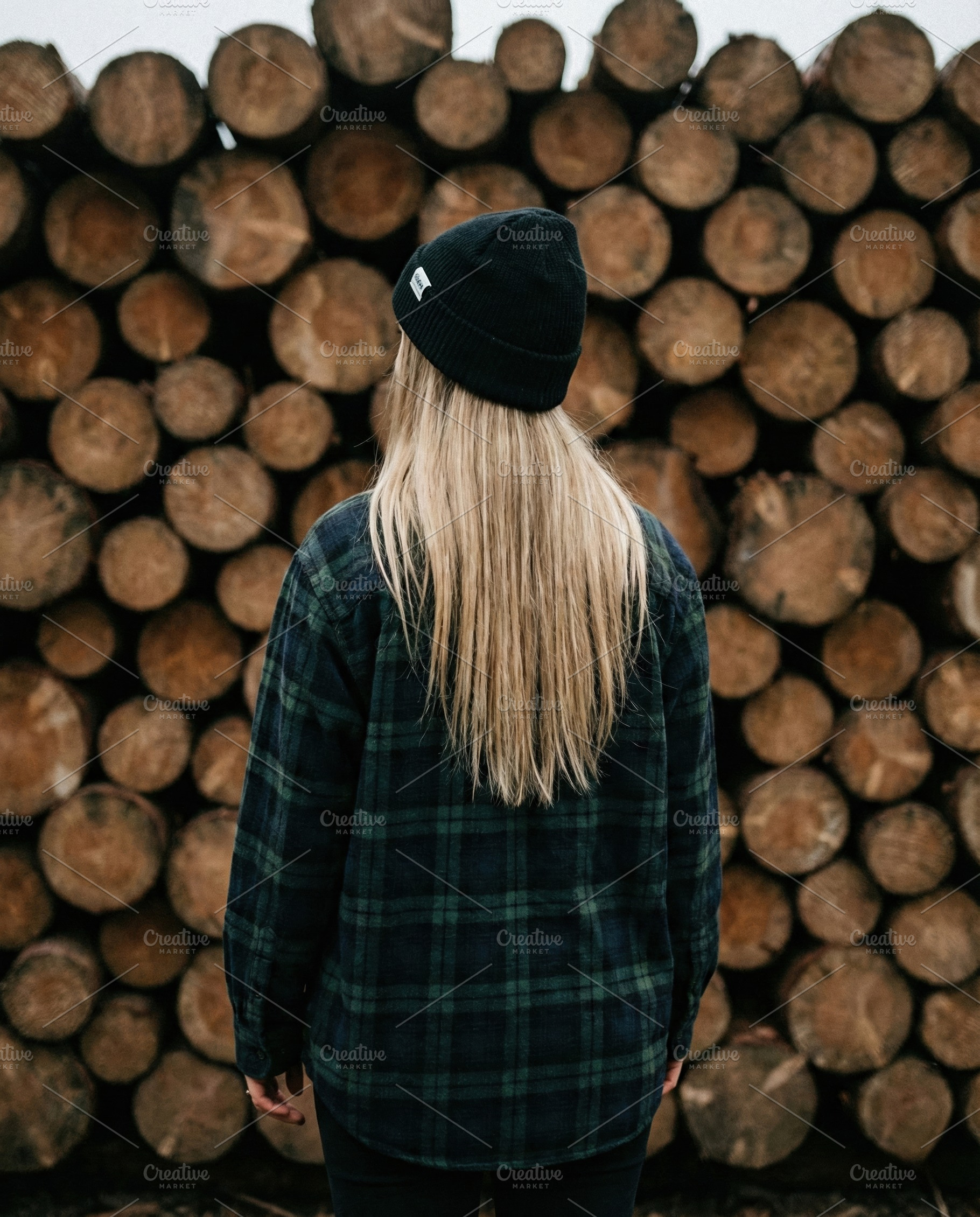 Woman in Beanie Against Log Pile, a Person Photo by Virgo Studio