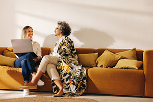 Two happy businesswomen working in an office lobby, a Person Photo by Jacob Lund