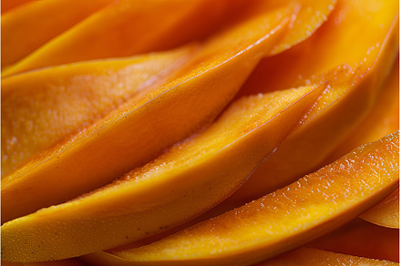 Close up of freshly cut mango slices, a Food & Drink Photo by Ylivdesign