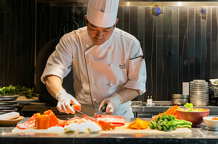A chef is meticulously slicing fresh, a Photo by Iftikhar Alam