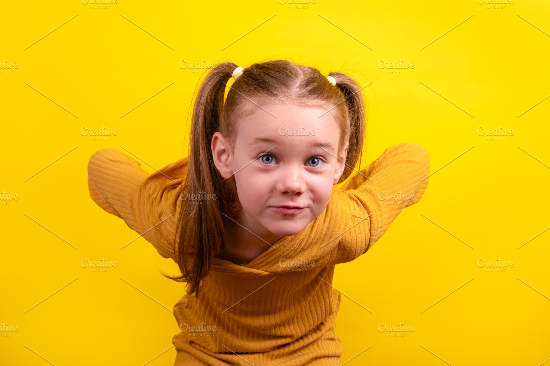 Cheerful young girl with pigtails and mustard yellow sweater pla, a Person Photo by Ales Munt