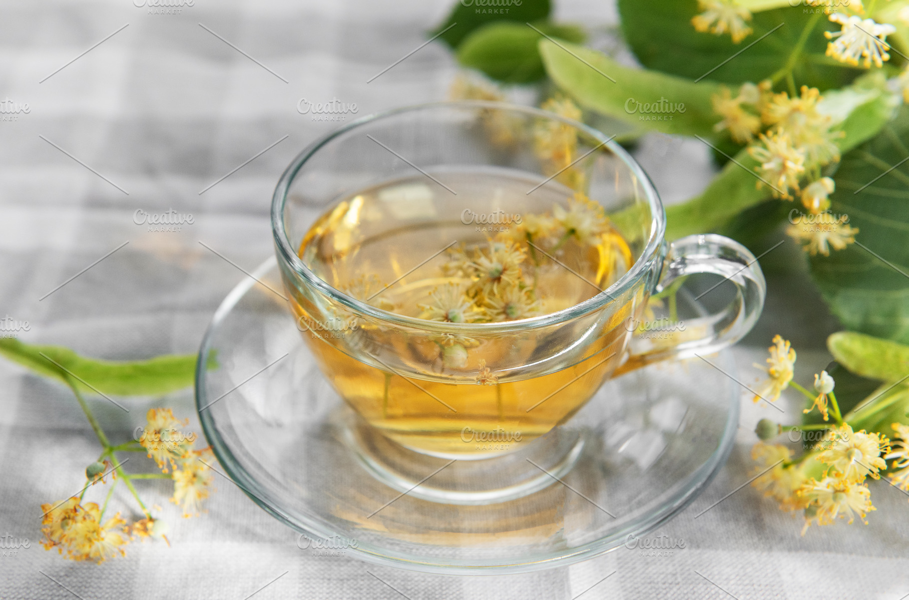Linden tea brewing with fresh tilia flowers and leaves, a Food & Drink Photo by Olena Rudo