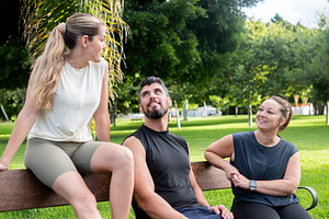Three fitness friends talking and relaxing on a park bench, a Food & Drink Photo by etorres69