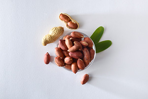 Peeled peanuts in glass bowl isolated on table top view, a Food & Drink Photo by Davizro's Market