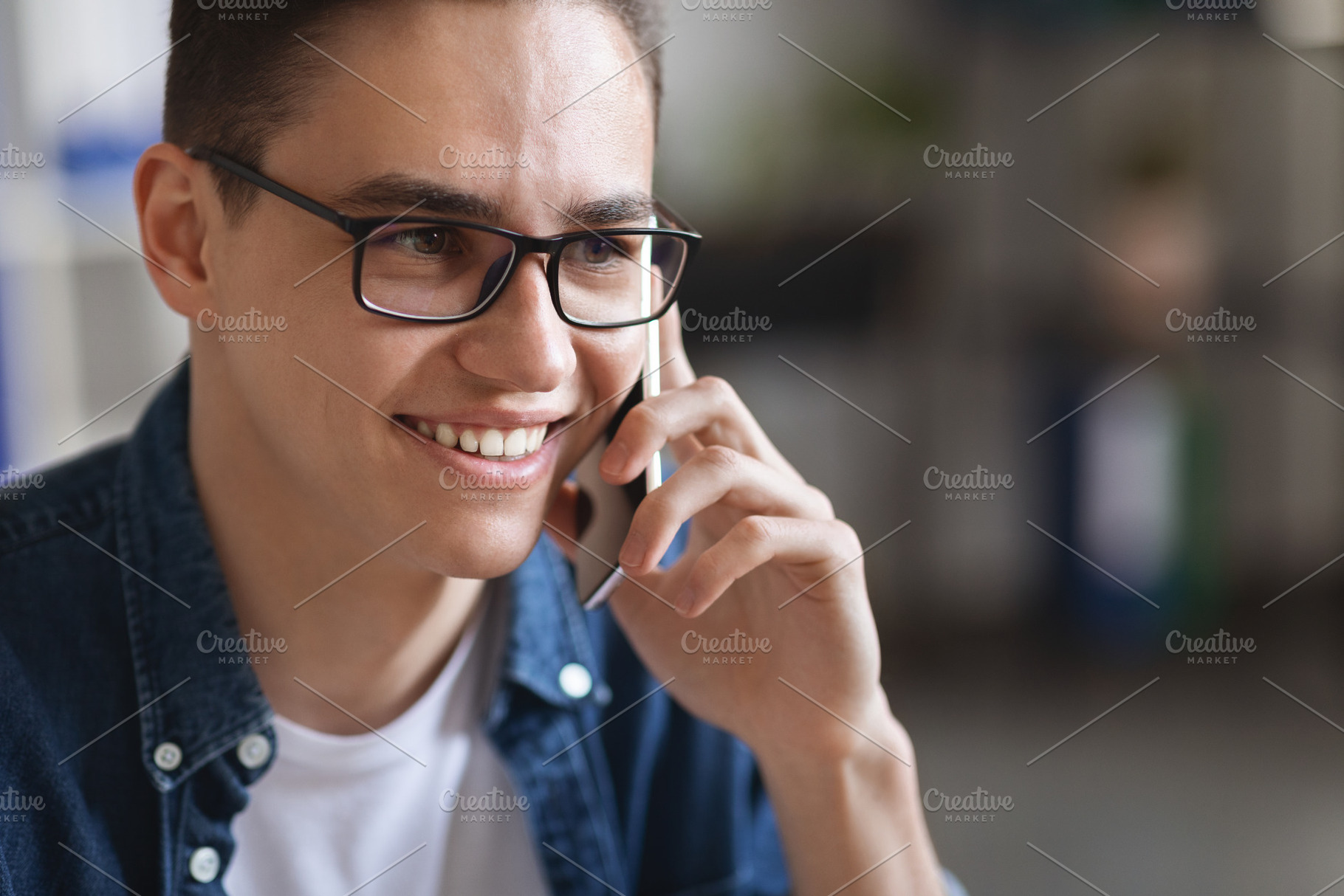 Close Up Of Millennial Handsome Man Wearing Eyeglasses Talking On Mobile Phone, a Photo by Prostock-Studio