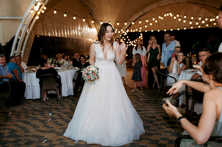 bride in a white dress throws a wedding bouquet
