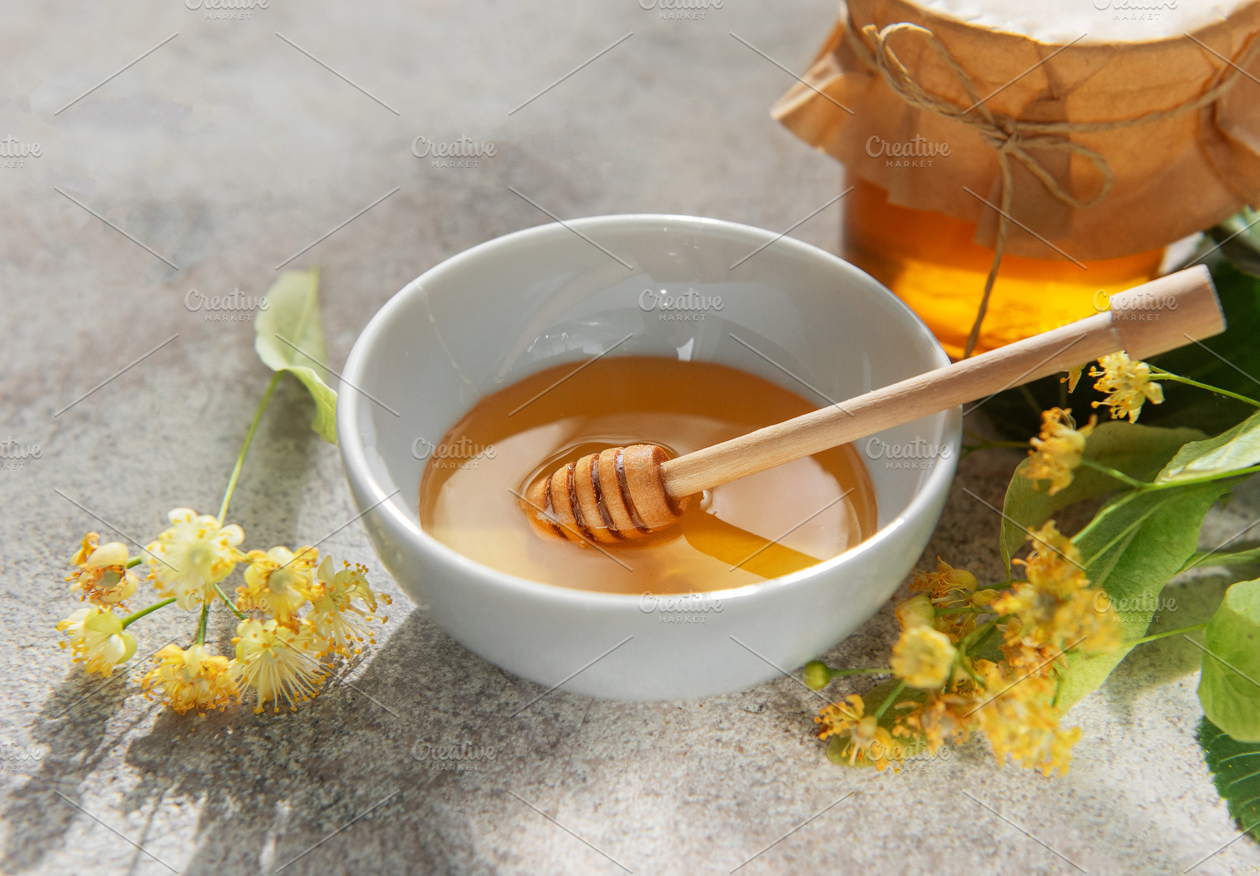 Linden honey bowl with wooden dipper and flowers, a Food & Drink Photo by Olena Rudo