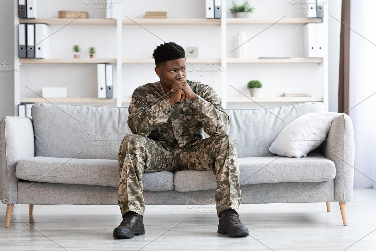 Pensive african american soldier in military uniform sitting on couch, a Photo by Prostock-Studio (Photo 3 of 5)