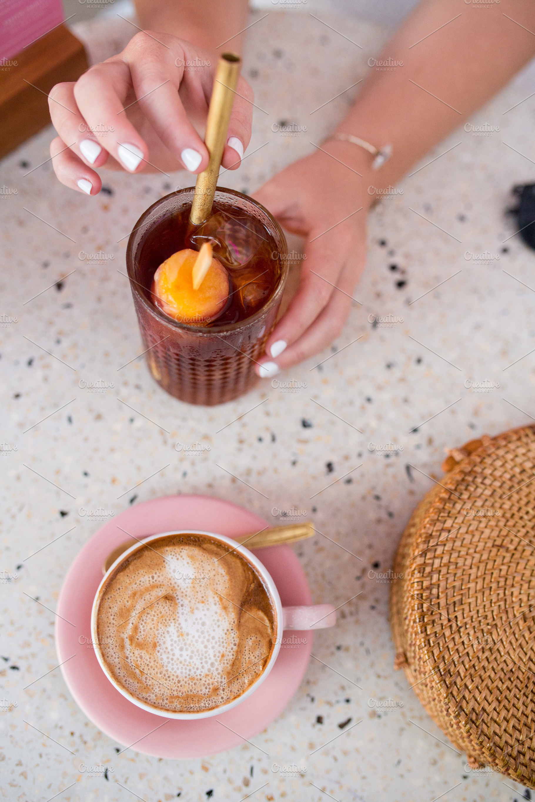 A hand with a cold drink and coffee, a Person Photo by Beach Babe Stock