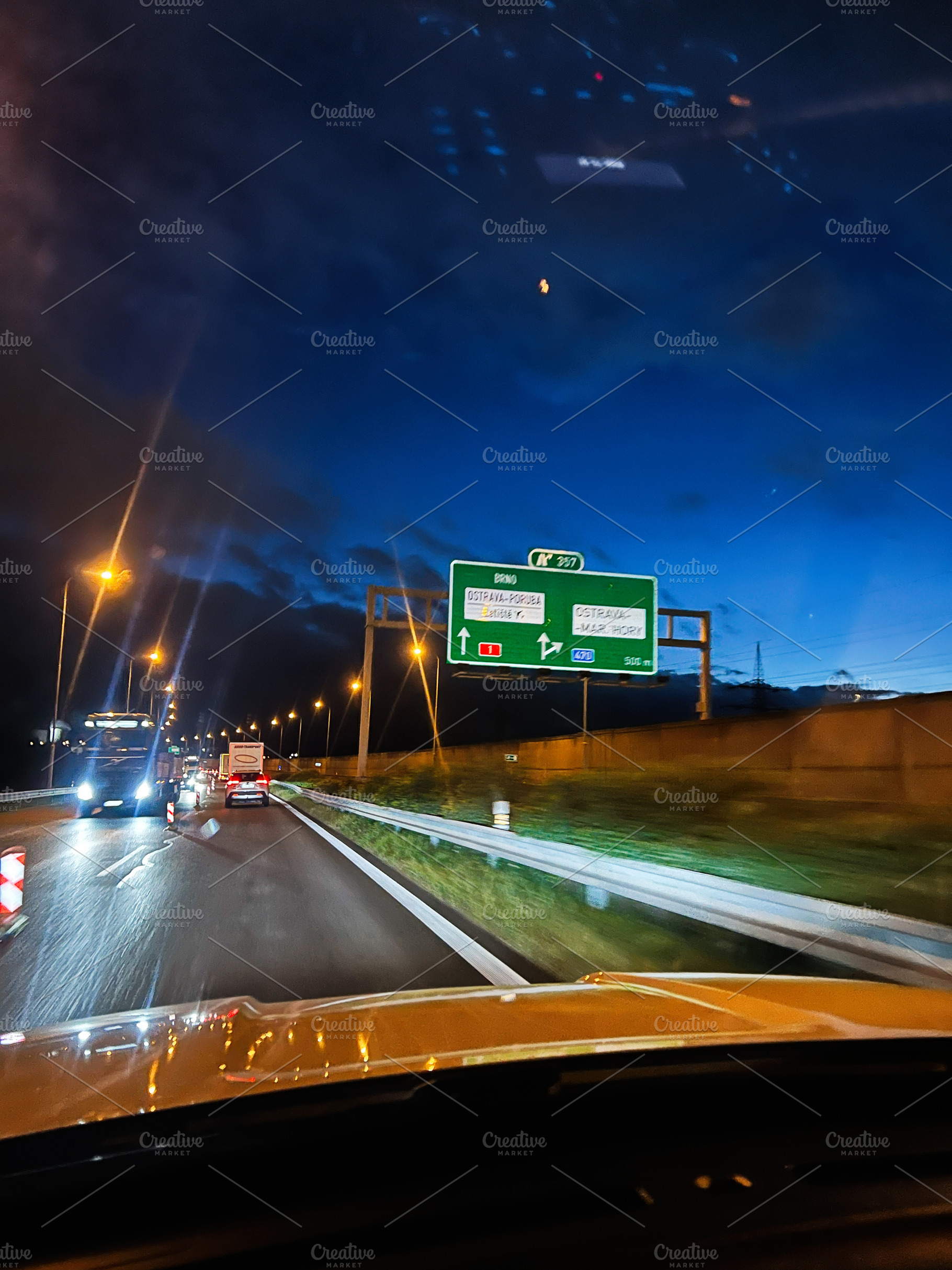 Evening highway drive with illuminated road signs and streetlights along a blue, a Photo by AS photostudio